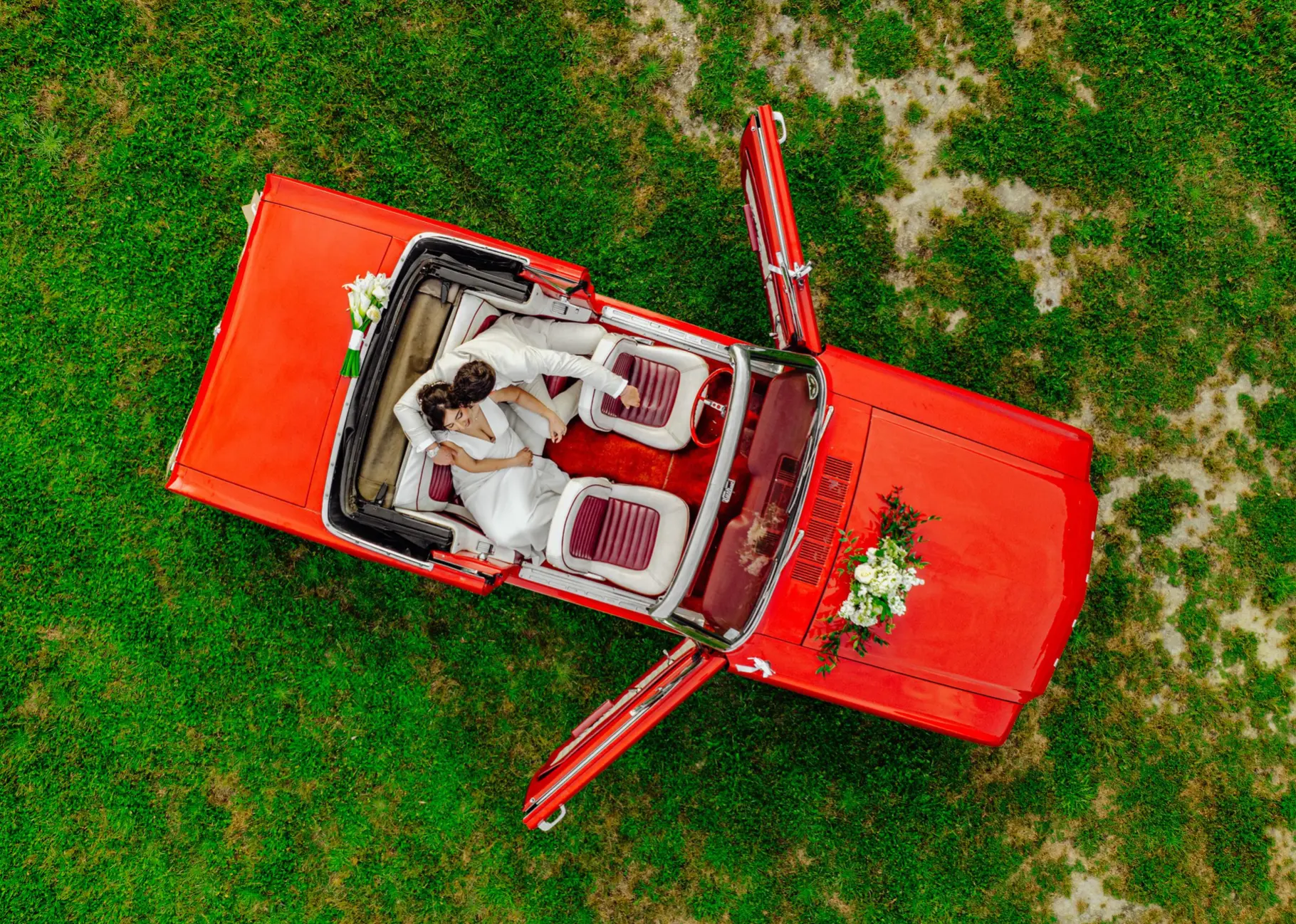 Aerial view of the couple in a red convertible